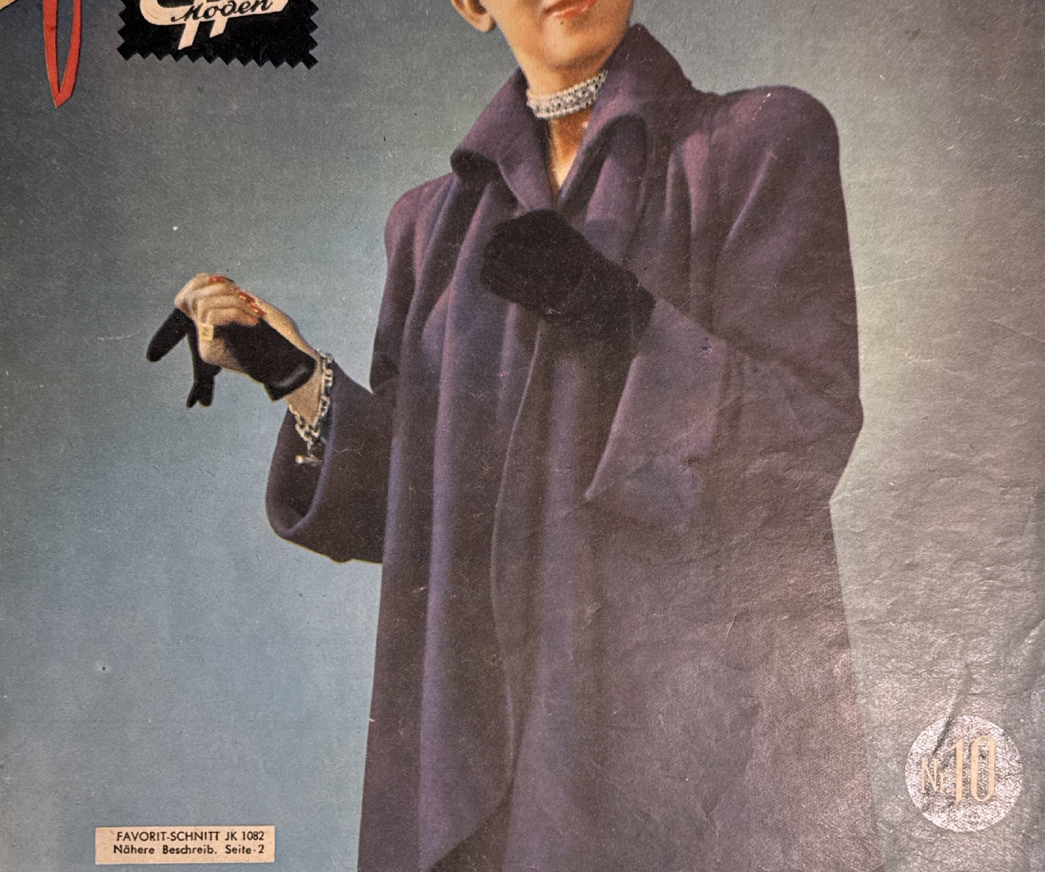 Detail of studio portrait in violet swing coat with pearl choker and black gloves